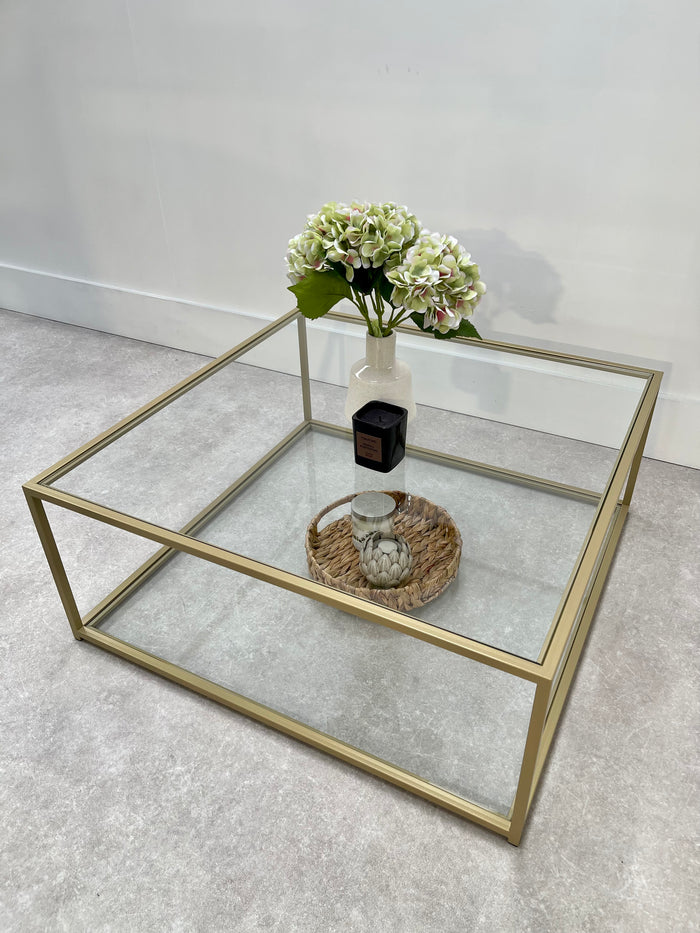 gold framed metal coffee table styled with a vase and basket tray