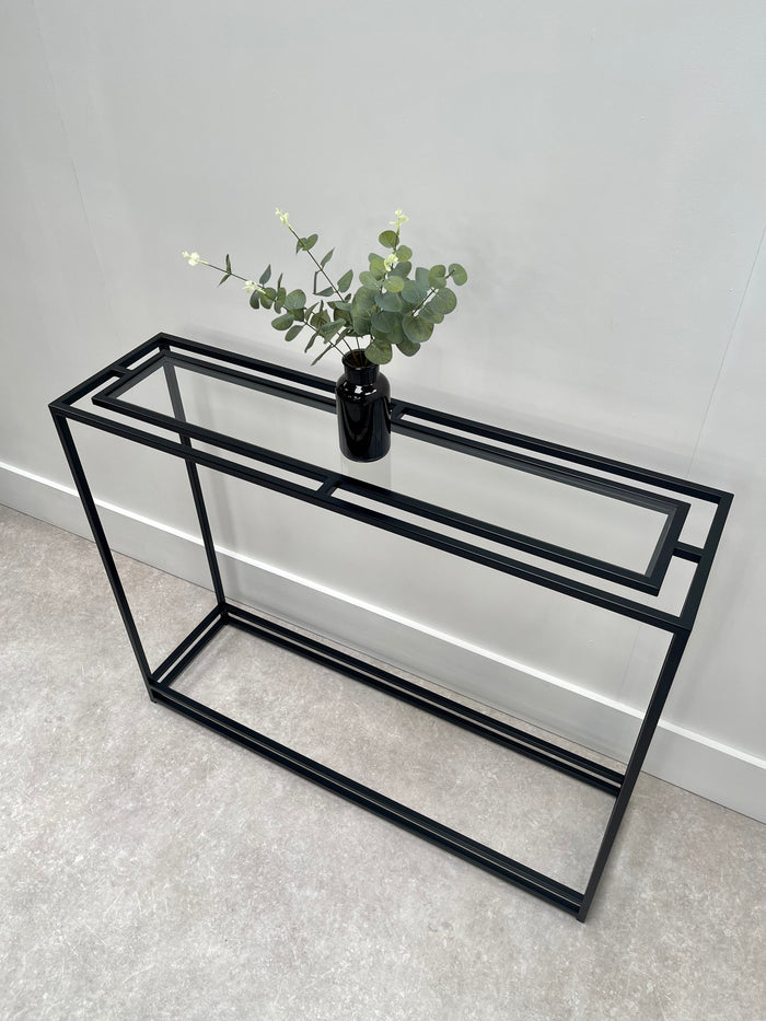 Thea console table with floating glass top and black metal frame 