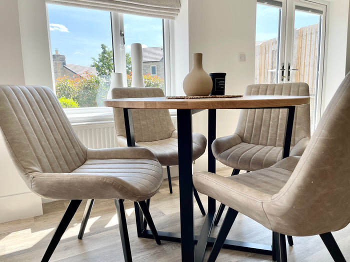 side view of a wooden top dining room table styled with chairs