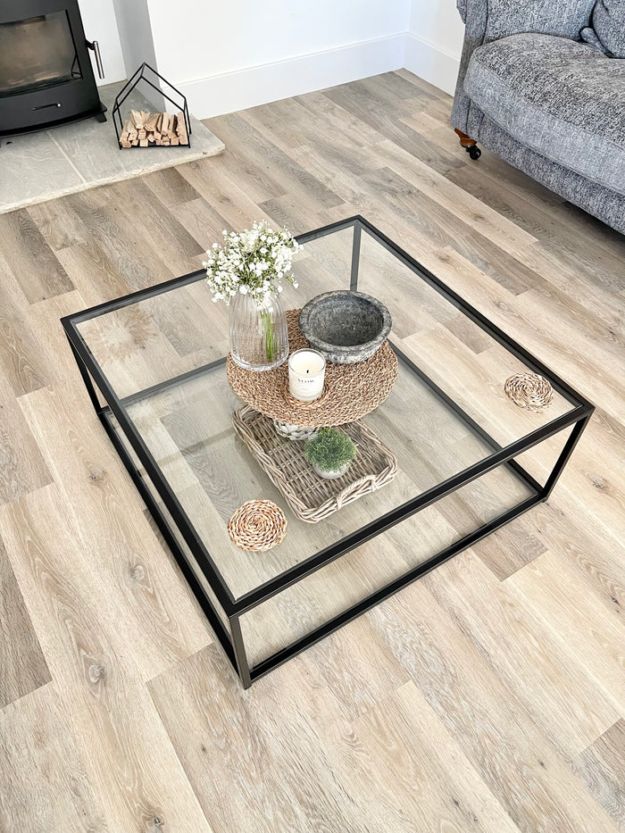 Birdseye view of a square coffee table styled with vases and candles  